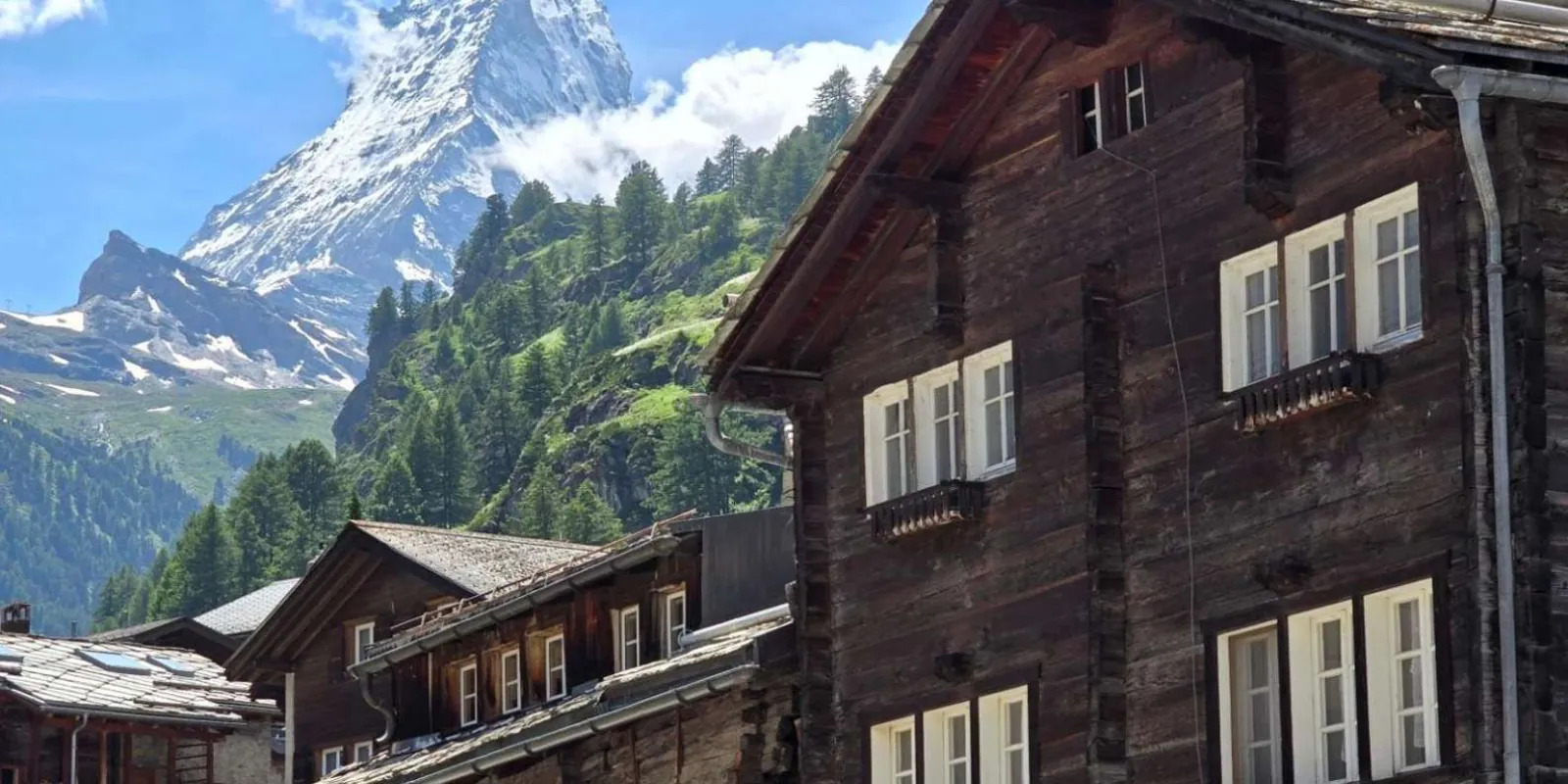 The gable of a dark timber Zermatt chalet with the snow-covered Matterhorn directly above