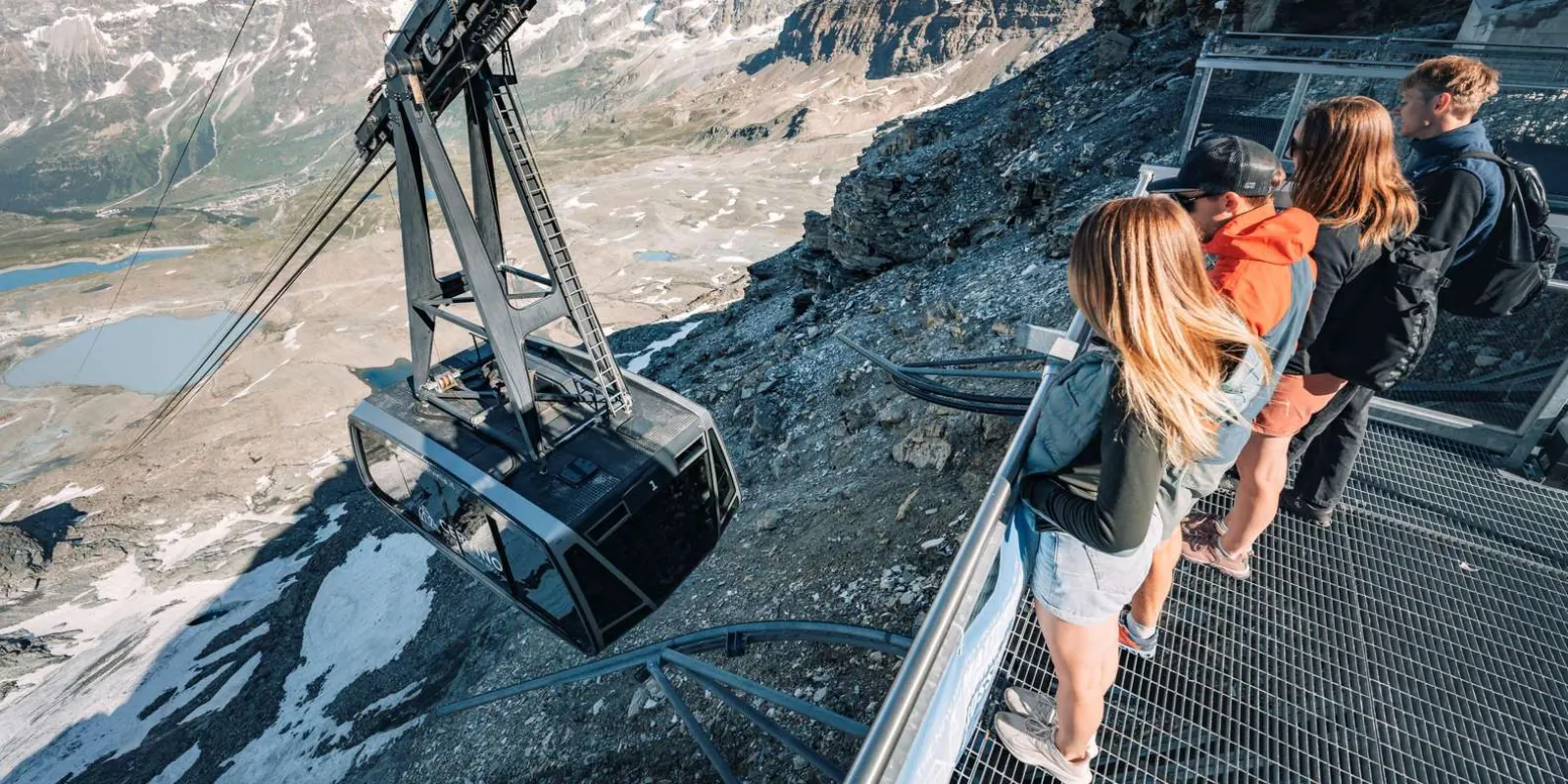 A cable car arriving at the summit viewing deck as visitors watch from the walkway